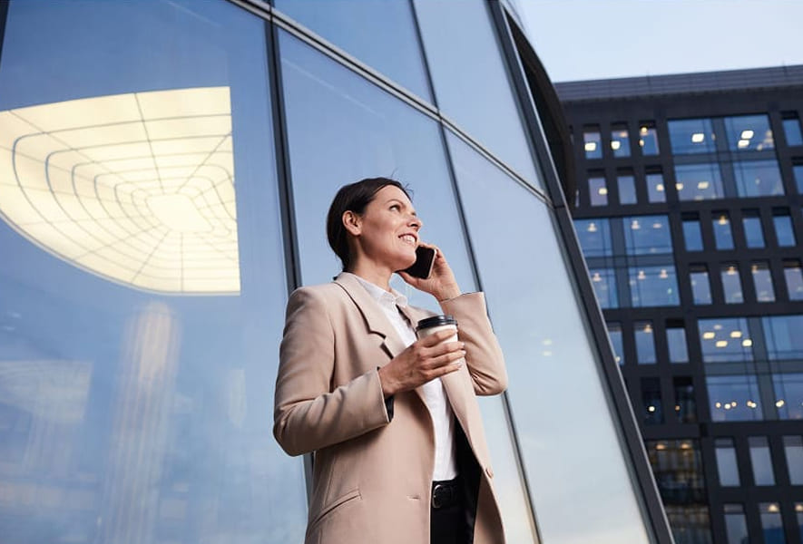 Corporate business advisor speaking on phone outside modern office building