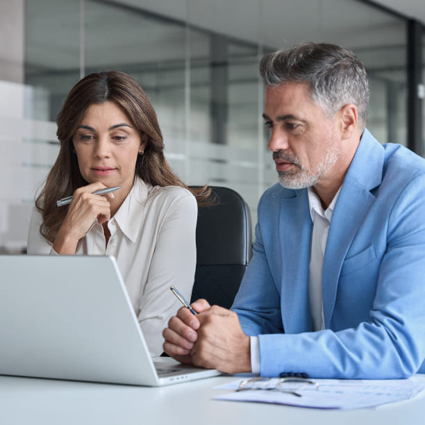 Business owners reviewing financial data with corporate broker during sale process